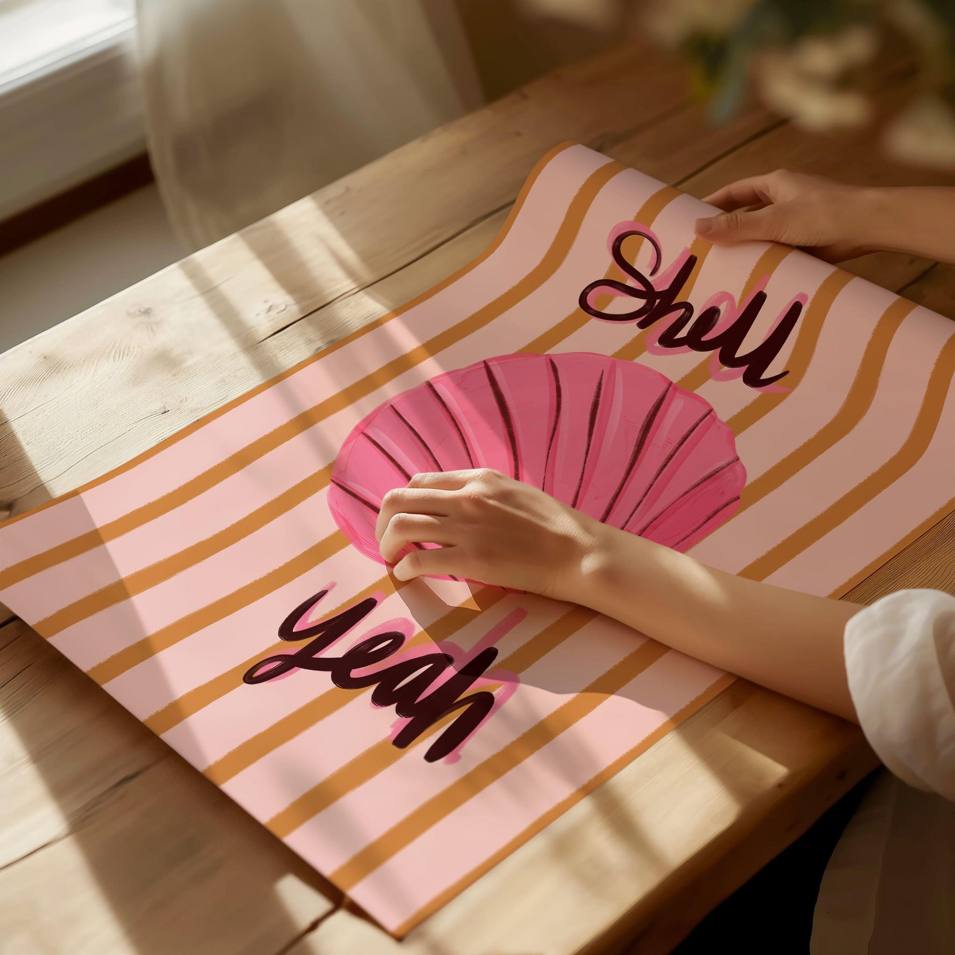 Painterly pink seashell art print with bold handwritten text "Shell Yeah". On a mustard yellow and pink striped background