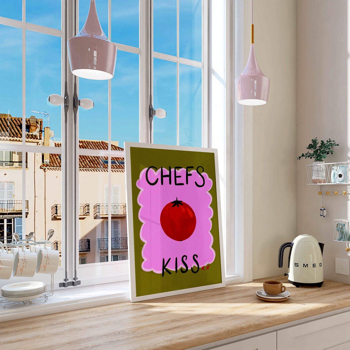 Bright kitchen nook wall art print featuring a painted red tomato with "chefs kiss" handwritten. On a green and pink textured background.