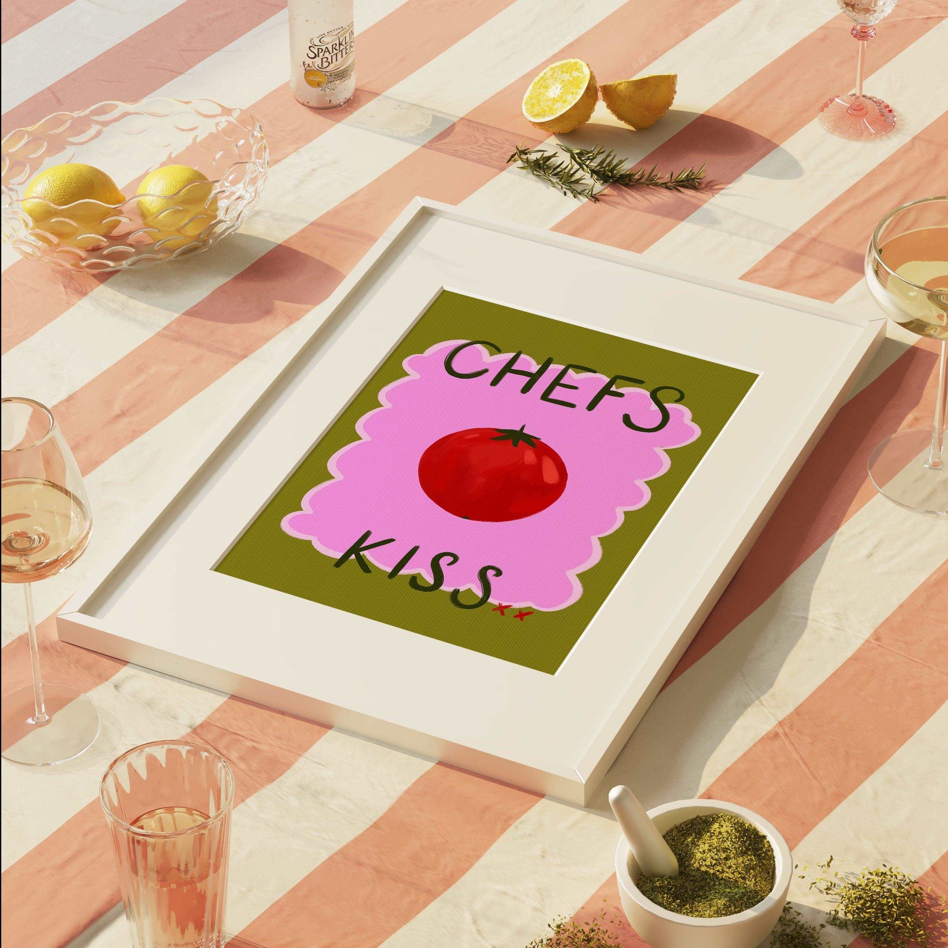 Bright funky kitchen art print featuring a painted red tomato with "chefs kiss" handwritten. On a green and pink textured background.