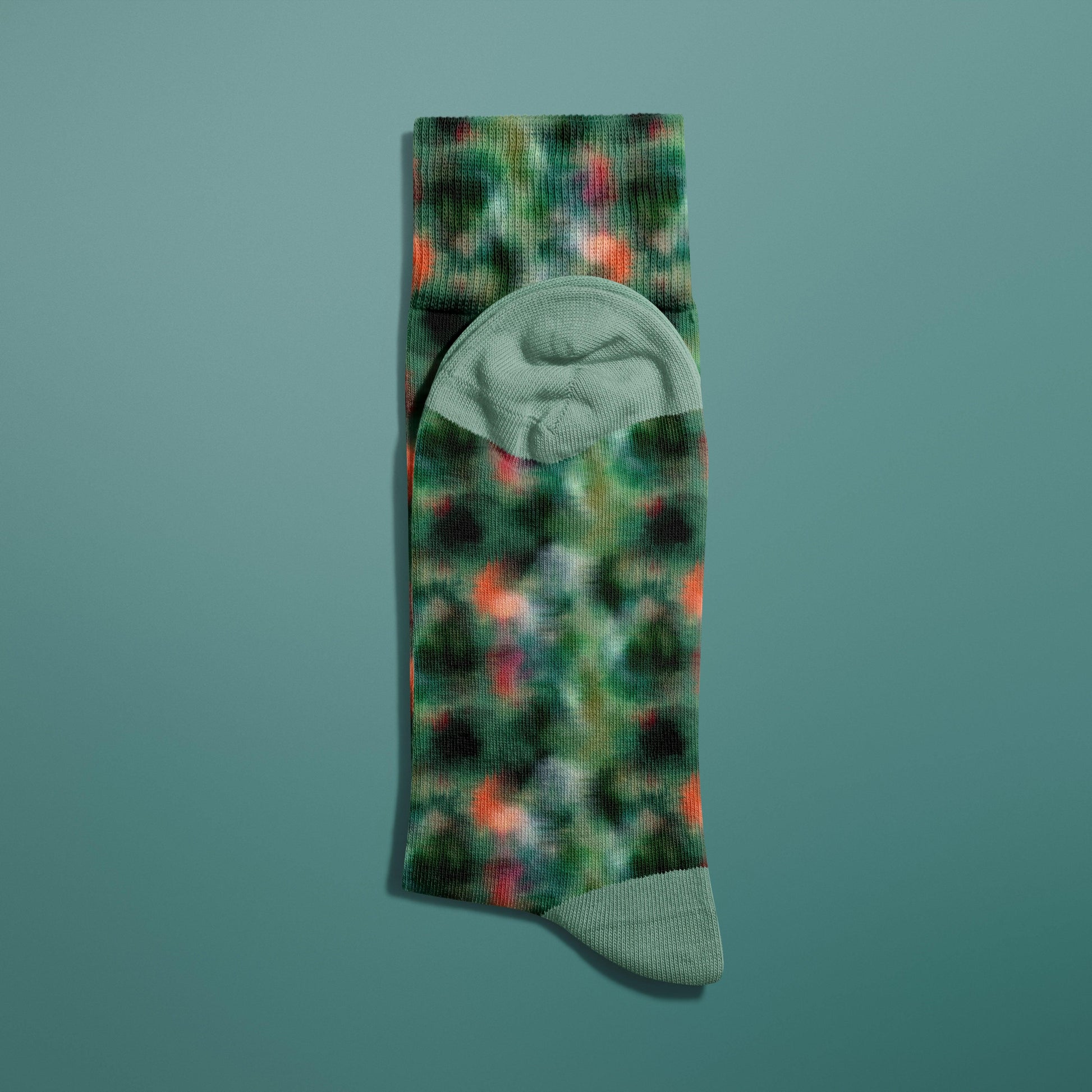 Green and orange abstract textured textile pattern on a pair of socks